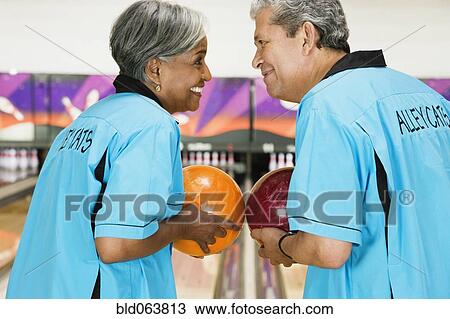 Stock Image - Two friends on bowling league about to bowl. Fotosearch