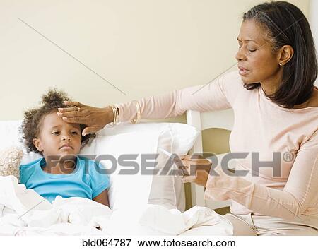 African grandmother checking granddaughter’s temperature View Large Photo Image Stock Photo - African grandmother checking granddaughter’s temperature. Fotosearch