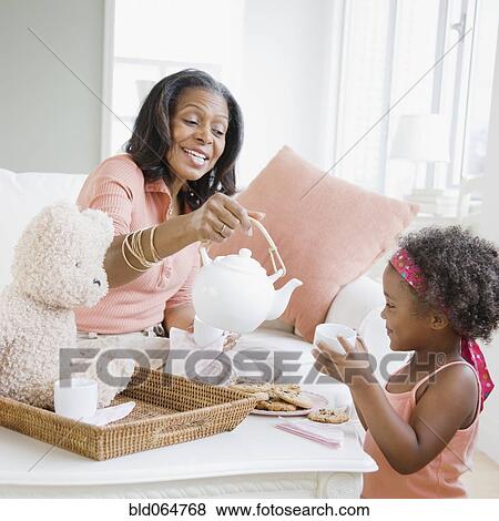 African grandmother having tea party with granddaughter View Large Photo Image Stock Photo - African grandmother having tea party with granddaughter. Fotosearch