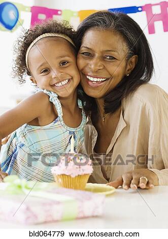 African grandmother hugging granddaughter on her birthday View Large Photo Image Stock Photo - African grandmother hugging granddaughter on her birthday. Fotosearch