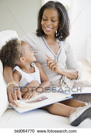 African grandmother looking a photo album with granddaughter View Large Photo Image Stock Image - African grandmother looking a photo album with granddaughter. Fotosearch