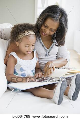 African grandmother looking a photo album with granddaughter View Large Photo Image Stock Photo - African grandmother looking a photo album with granddaughter. Fotosearch