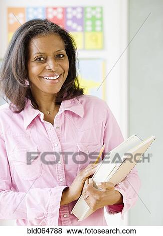 Stock Photo - African teacher standing in classroom. Fotosearch