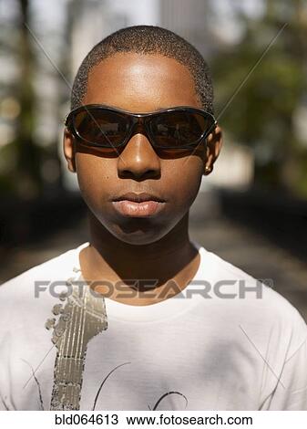 Stock Image - African teenage boy wearing sunglasses. Fotosearch