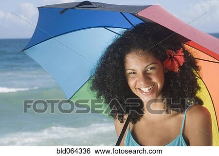 African woman at beach with umbrella View Large Photo Image Stock Photograph - African woman at beach with umbrella. Fotosearch