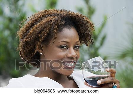 Stock Photograph - African woman drinking red wine. Fotosearch