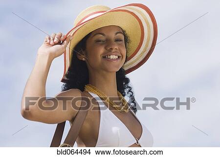 Picture - African woman in bikini and sunhat. Fotosearch