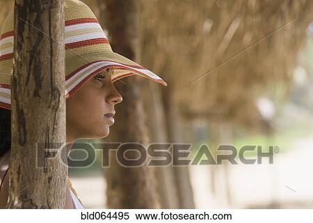 Stock Photography - African woman in sunhat at beach. Fotosearch