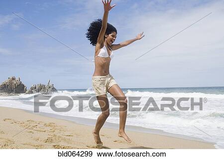 African woman jumping at beach View Large Photo Image Stock Photo - African woman jumping at beach. Fotosearch