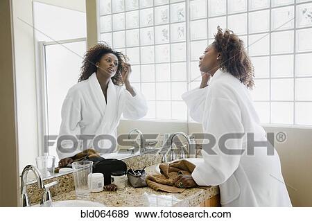 African woman putting on makeup in bathroom View Large Photo Image Stock Photo - African woman putting on makeup in bathroom. Fotosearch