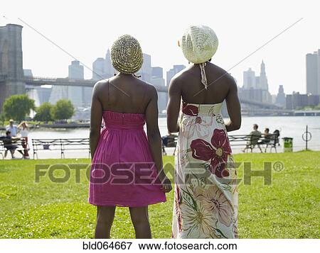 African woman standing at urban waterfront with friend View Large Photo Image Stock Photo - African woman standing at urban waterfront with friend. Fotosearch