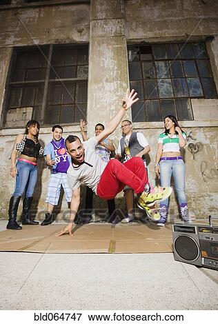 Stock Photo - Alternative friends break dancing in urban setting. Fotosearch