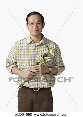 Stock Image - Asian man holding bouquet of flowers. Fotosearch
