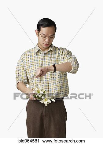 Asian man holding bouquet of flowers and checking watch View Large Photo Image Stock Image - Asian man holding bouquet of flowers and checking watch. Fotosearch