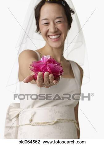 Asian woman in wedding dress holding flower View Large Photo Image Stock Image - Asian woman in wedding dress holding flower. Fotosearch