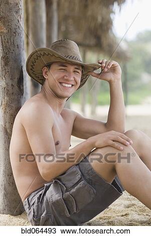 Stock Image - Bare chested Hispanic man in cowboy hat. Fotosearch