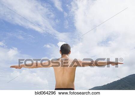 Stock Photograph - Bare chested Hispanic man with arms out. Fotosearch