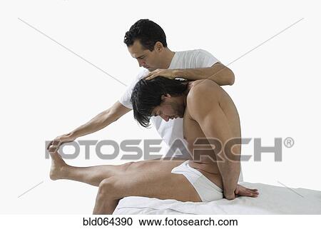 Stock Image - Chiropractor adjusting man’s back. Fotosearch