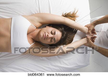 Stock Image - Chiropractor adjusting woman’s spine. Fotosearch