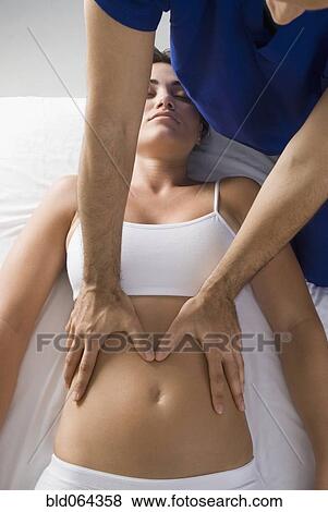 Stock Photo - Chiropractor adjusting woman’s spine. Fotosearch