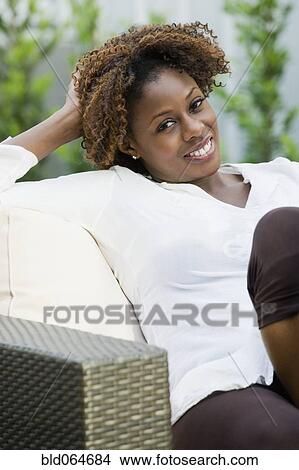 Picture - Confident African woman sitting in armchair. Fotosearch