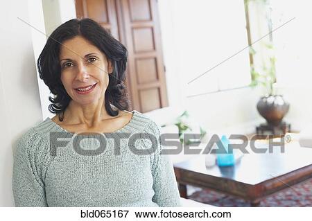 Confident Middle Eastern woman in living room View Large Photo Image Stock Photo - Confident Middle Eastern woman in living room. Fotosearch