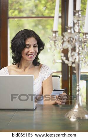 Confident Middle Eastern woman shopping online with credit card View Large Photo Image Stock Photography - Confident Middle Eastern woman shopping online with credit card. Fotosearch