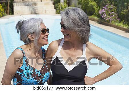 Friends at poolside in bathing suits and sunglasses View Large Photo Image Stock Photo - Friends at poolside in bathing suits and sunglasses. Fotosearch
