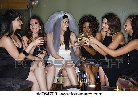 Stock Photo - Friends drinking cocktails with bride in nightclub. Fotosearch
