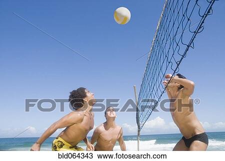Friends playing volleyball at beach View Large Photo Image Stock Image - Friends playing volleyball at beach. Fotosearch
