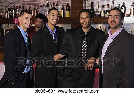 Stock Photo - Group of multi-ethnic businessmen drinking in bar. Fotosearch