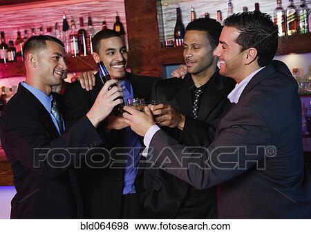 Stock Photo - Group of multi-ethnic businessmen drinking in bar. Fotosearch