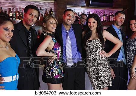 Stock Image - Group of multi-ethnic people enjoying nightclub. Fotosearch
