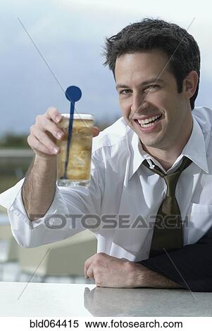 Stock Photography - Hispanic businessman drinking cocktail. Fotosearch