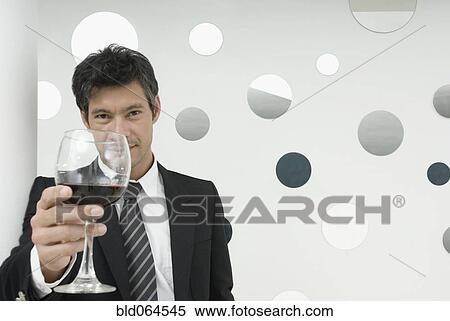 Stock Photography - Hispanic businessman drinking wine. Fotosearch