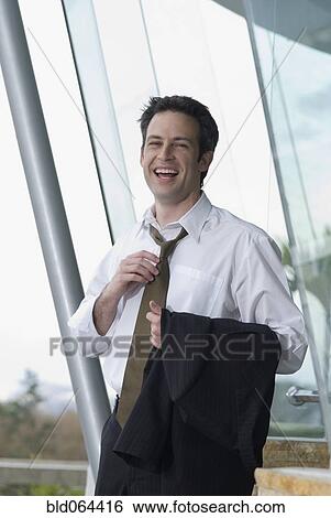 Stock Photograph - Hispanic businessman loosening necktie. Fotosearch