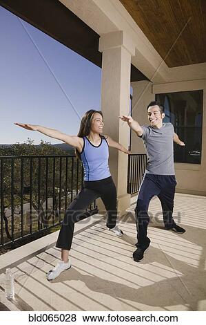 Hispanic couple doing yoga on balcony View Large Photo Image Stock Photo - Hispanic couple doing yoga on balcony. Fotosearch