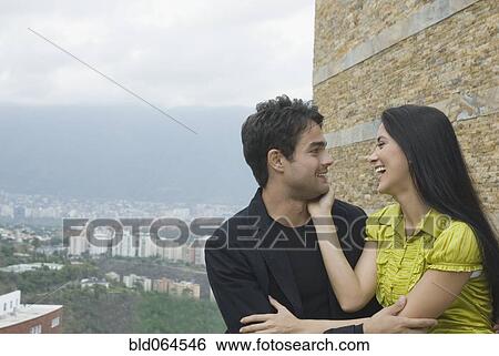 Hispanic couple laughing in urban setting View Large Photo Image Stock Photograph - Hispanic couple laughing in urban setting. Fotosearch