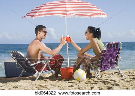Hispanic couple relaxing at beach View Large Photo Image Stock Image - Hispanic couple relaxing at beach. Fotosearch
