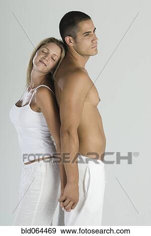 Stock Photo - Hispanic couple standing back to back. Fotosearch