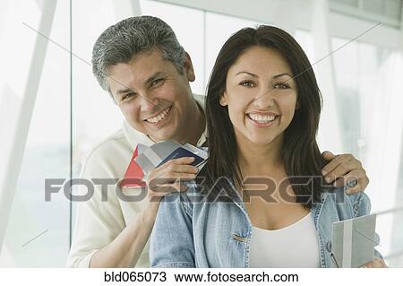 Stock Image - Hispanic couple standing in airport. Fotosearch