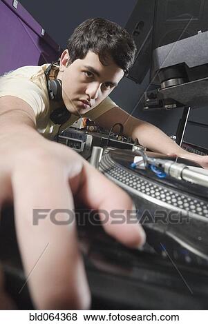 Stock Photo - Hispanic DJ performing in nightclub. Fotosearch