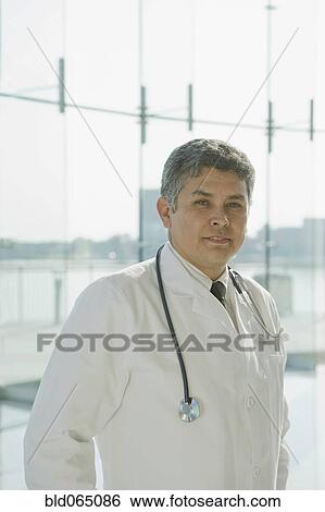Hispanic doctor in lab coat and stethoscope View Large Photo Image Stock Photograph - Hispanic doctor in lab coat and stethoscope. Fotosearch