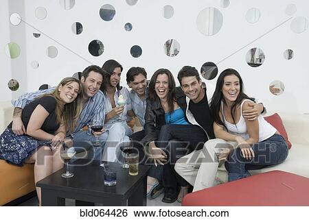Stock Photograph - Hispanic friends drinking cocktails. Fotosearch