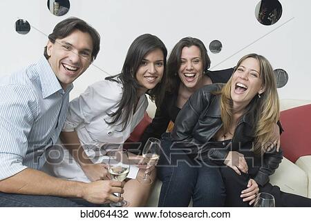 Stock Image - Hispanic friends drinking in nightclub. Fotosearch