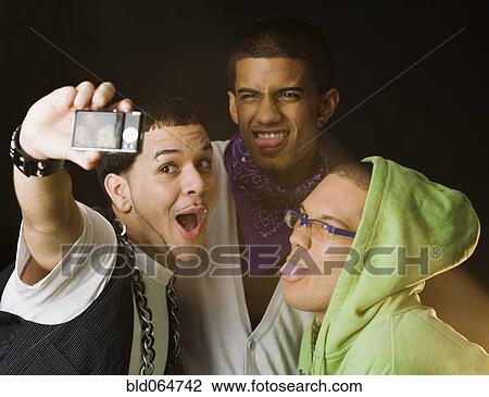 Hispanic friends making faces for self-portrait View Large Photo Image Stock Image - Hispanic friends making faces for self-portrait. Fotosearch