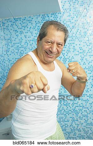 Picture - Hispanic man boxing in bathroom. Fotosearch