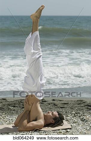Hispanic man doing yoga at beach View Large Photo Image Stock Photo - Hispanic man doing yoga at beach. Fotosearch