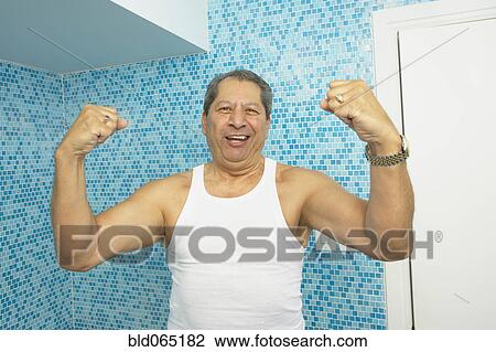 Hispanic man flexing his biceps in bathroom View Large Photo Image Stock Image - Hispanic man flexing his biceps in bathroom. Fotosearch