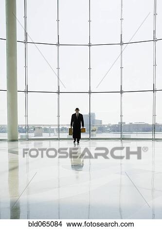 Hispanic man holding luggage in airport View Large Photo Image Picture - Hispanic man holding luggage in airport. Fotosearch